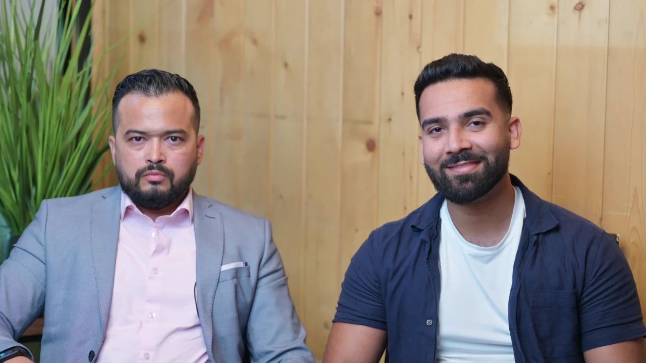 The two founders seated together, one smiling toward the camera